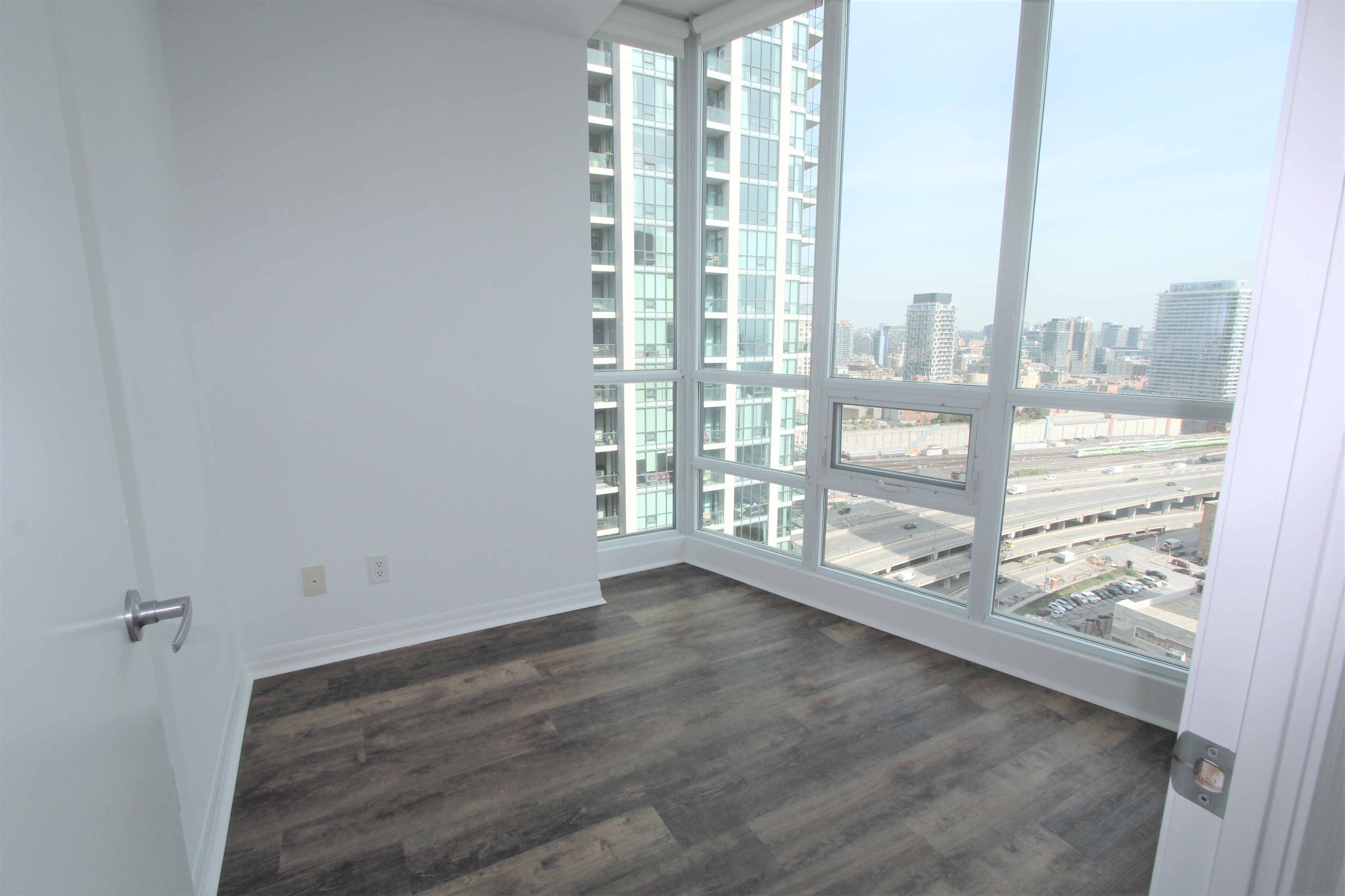 Open-concept living and dining with floor-to-ceiling windows and partial lake view