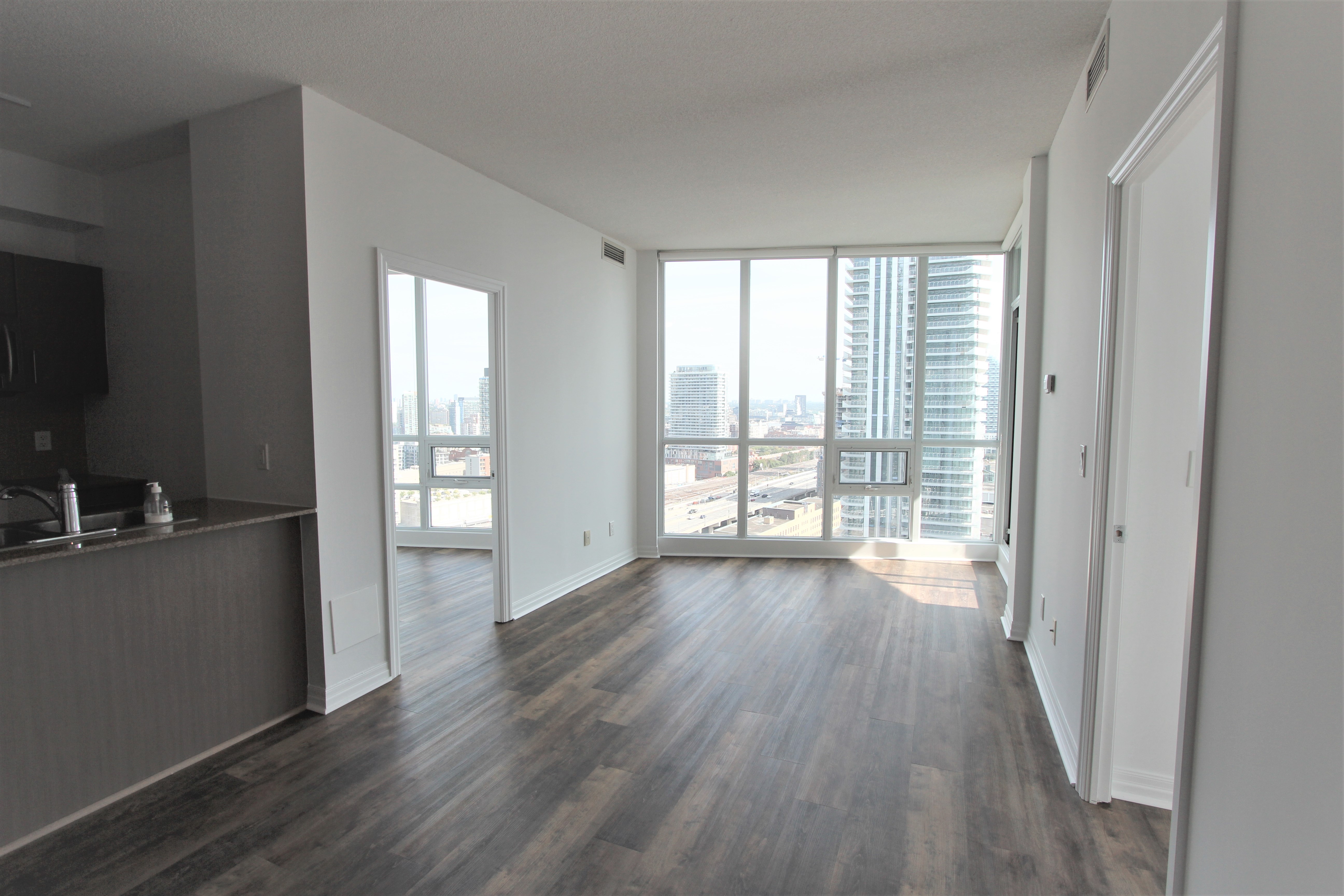 Living area with vinyl flooring and city views from 26th floor