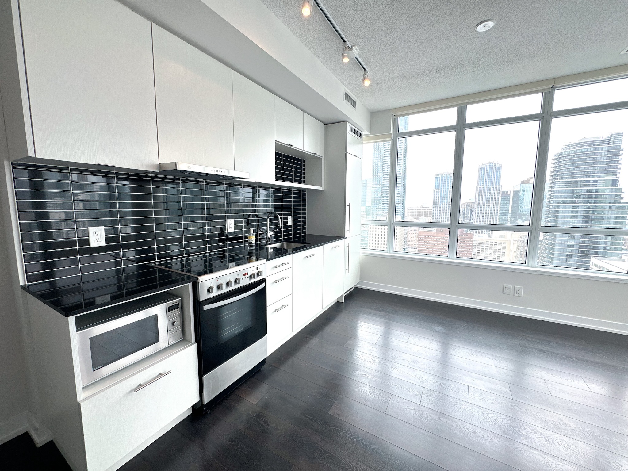 Living area with large windows and laminate flooring