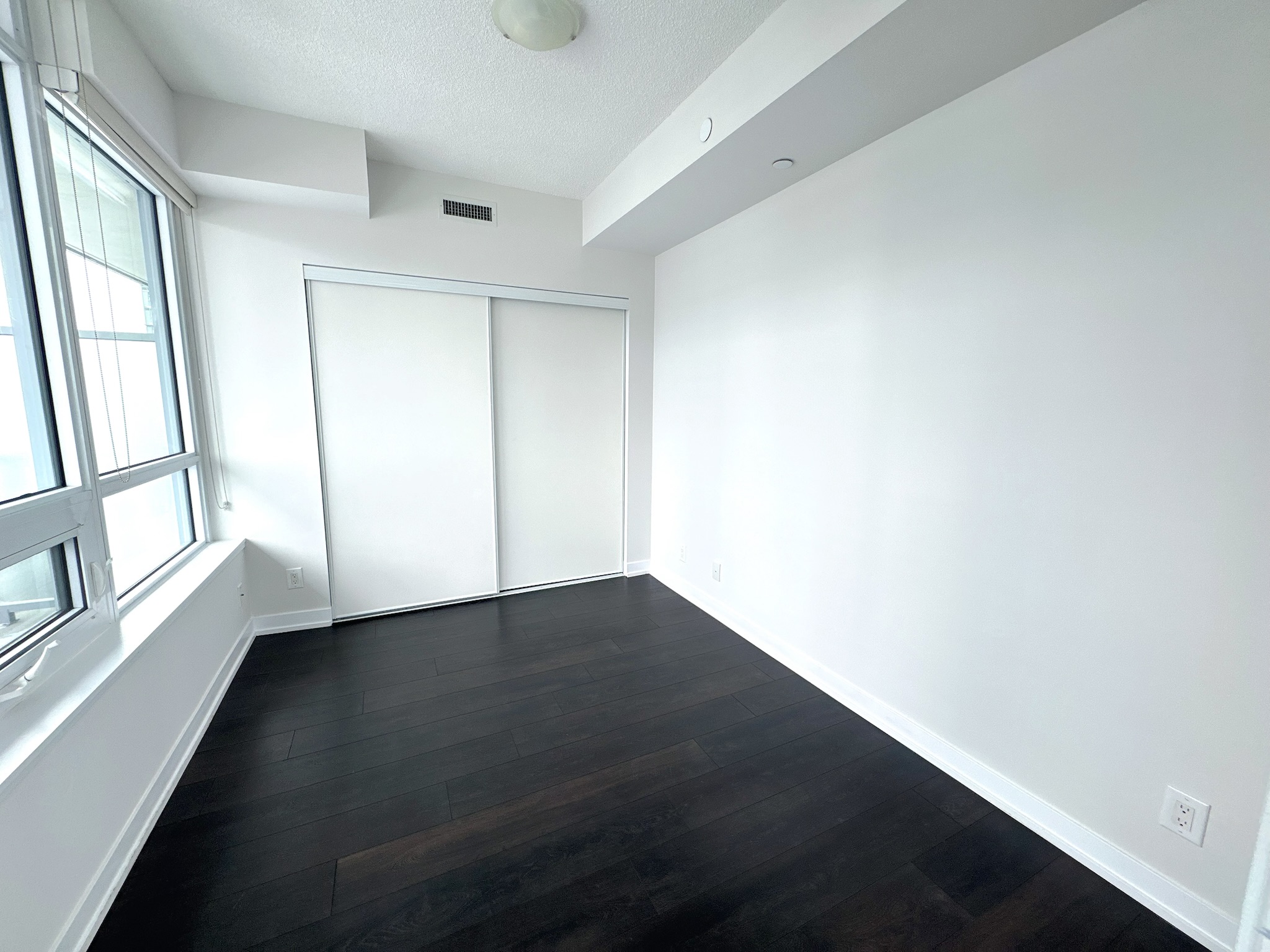 Primary bedroom with large closet and laminate flooring