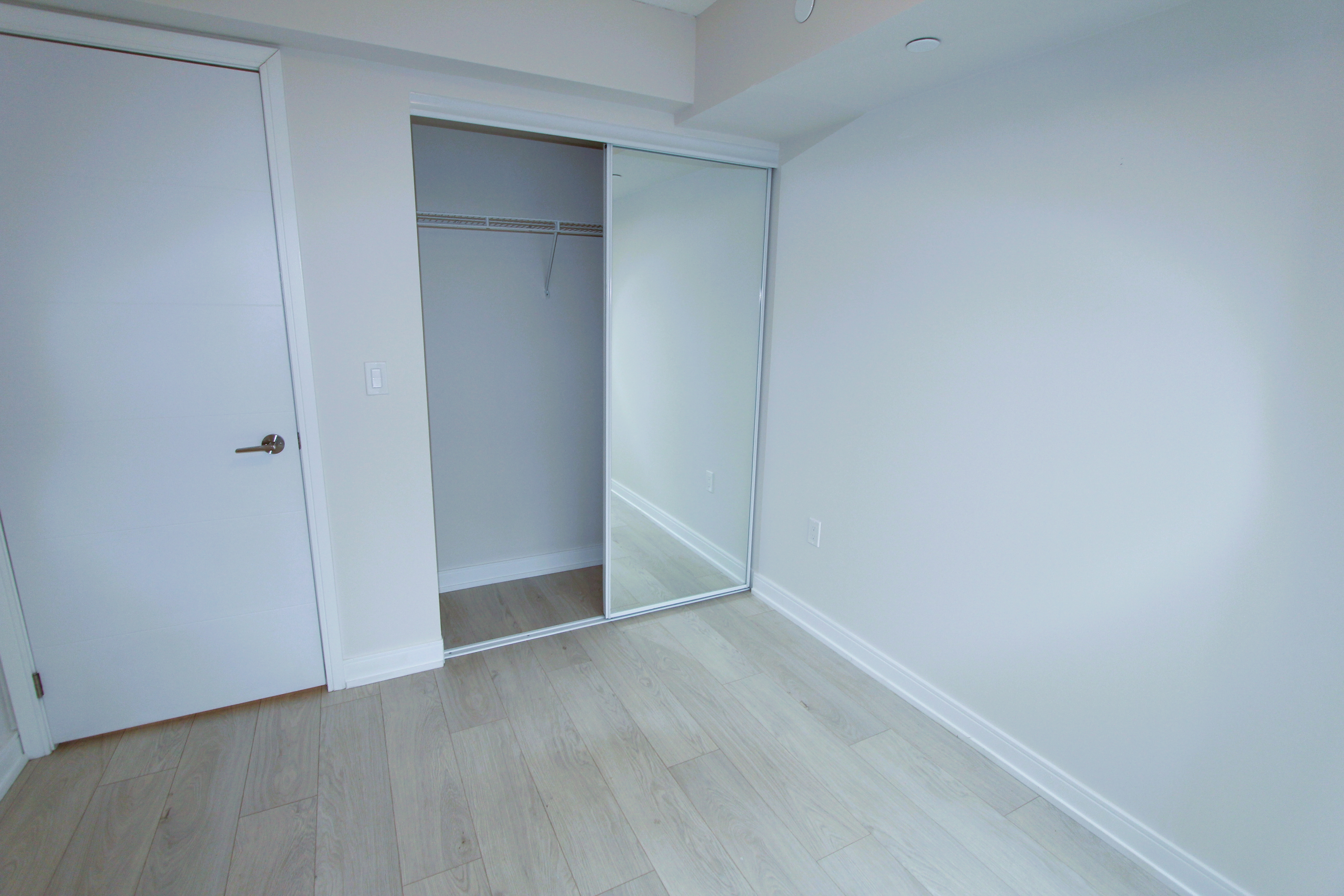 Primary bedroom — laminate flooring and natural light