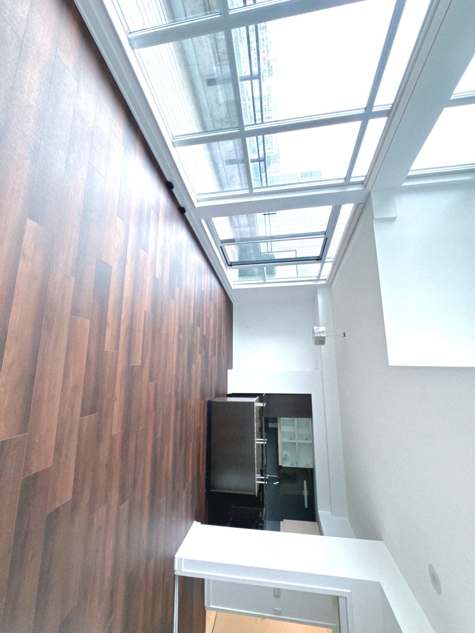 Main level open-concept living area with floor-to-ceiling windows and balcony access